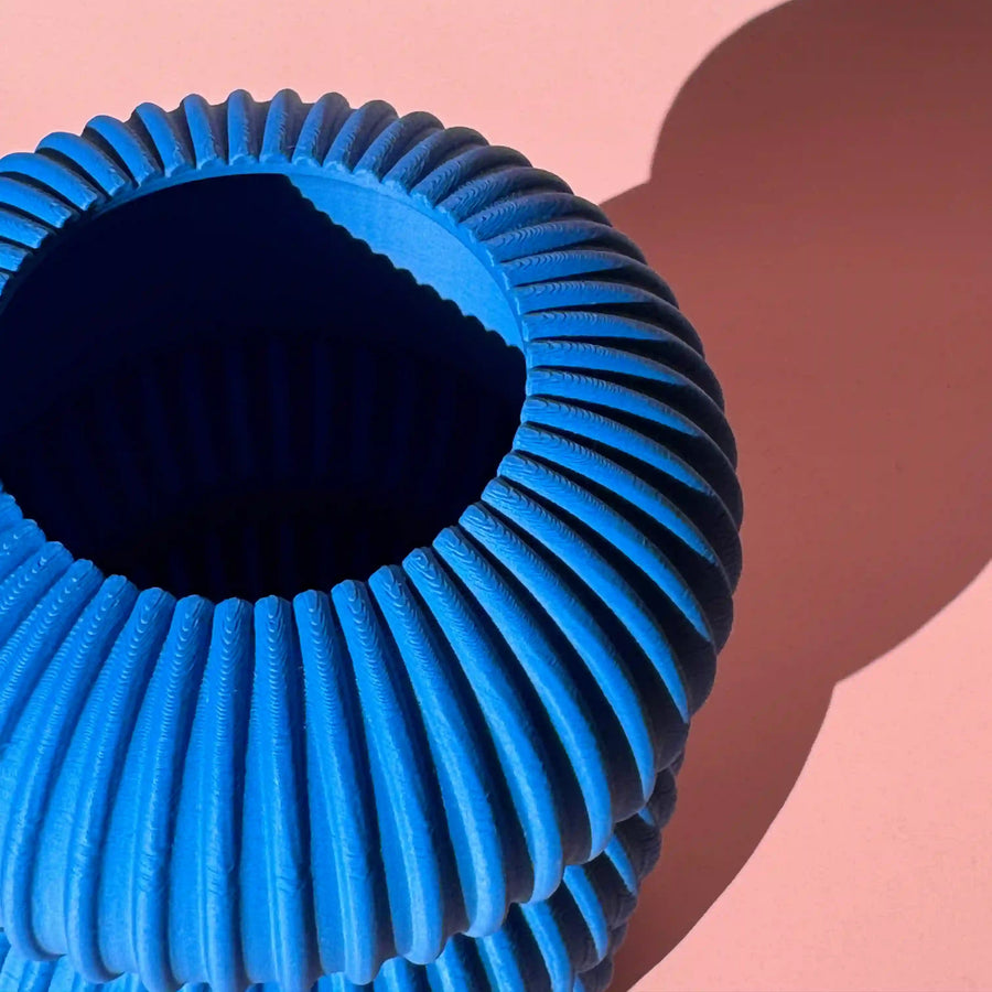 Close up von einer blauen 3D Vase auf rosa Hintergund