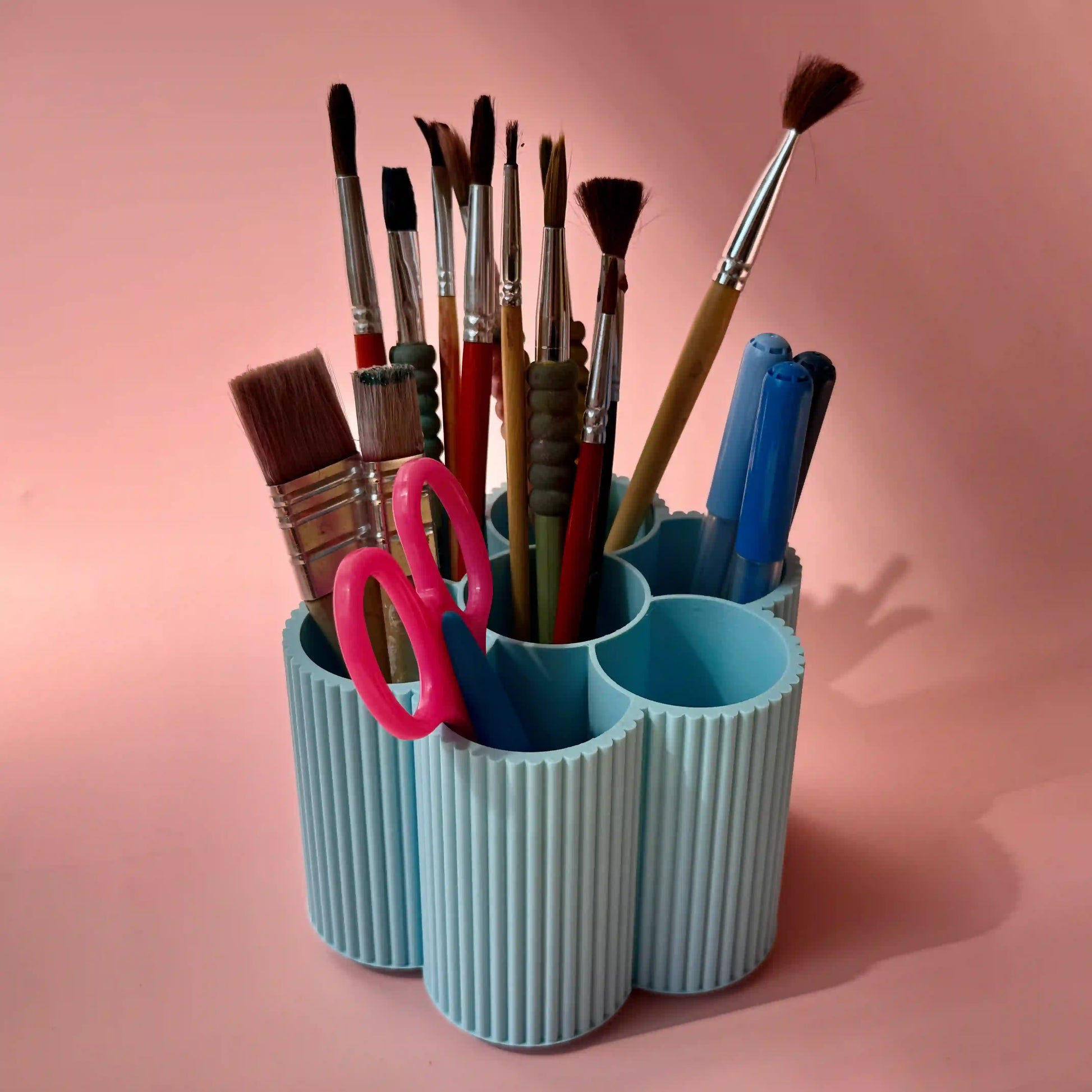 Stiftebox Blume von tryk.design vor rosa Hintergrund mit Stiften, Pinsel und Schere