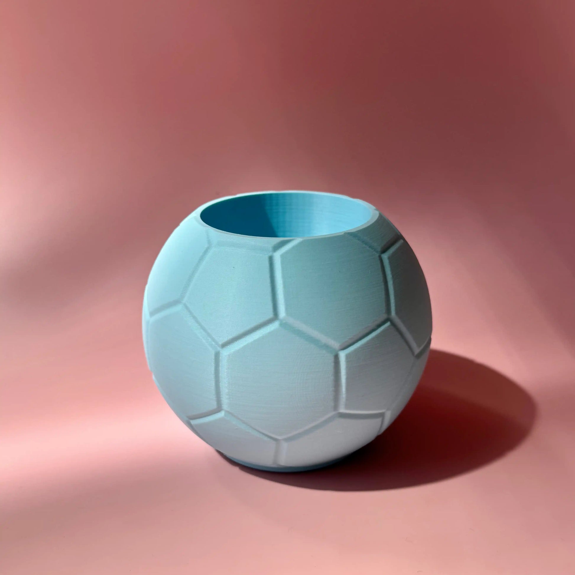 Hellblaue Fussball Stiftebox vor rosa Huntergrund