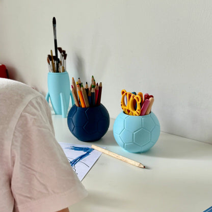Dunkelblaue und Hellblaue Stiftebox in Fussball Design auf Schreibtisch