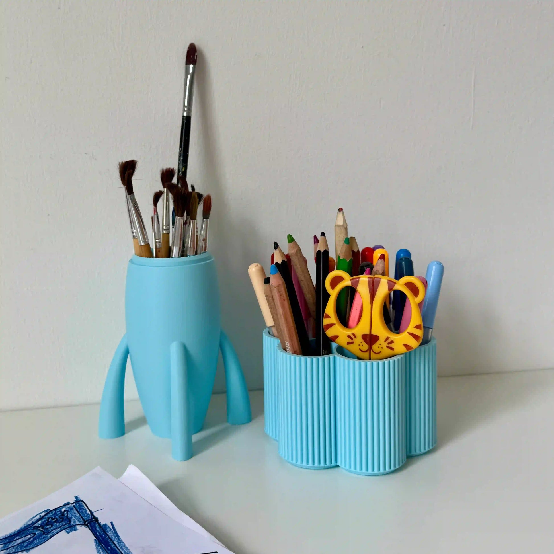 Hellblaue Rakete und hellblaue Blumen Stiftebox auf Schreibtisch