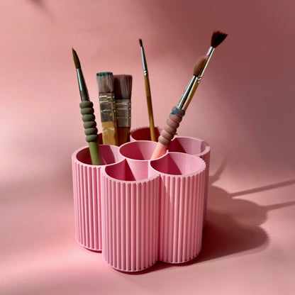Rosa Blumen-Stiftebox mit Pinseln vor rosa Huntergrund von tryk.design